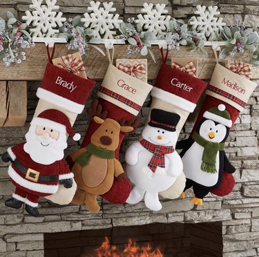 Four holiday-themed stockings on mantel