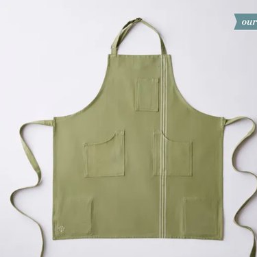 An "Ultimate Apron" from Five Two, in its khaki-like green "Eucalyptus" color, shown on a pale gray ground