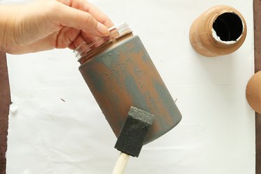 Applying gray paint on a jar