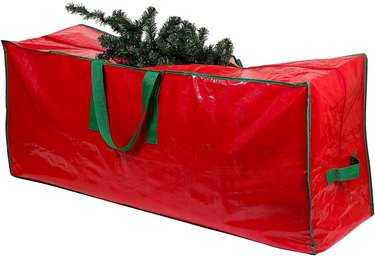 Red Christmas tree storage bag with green handles. It's made of tarp material and fits trees 9 feet and under.