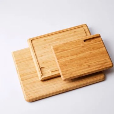 Bamboo cutting boards from Food52 in all three sizes, on a grey countertop