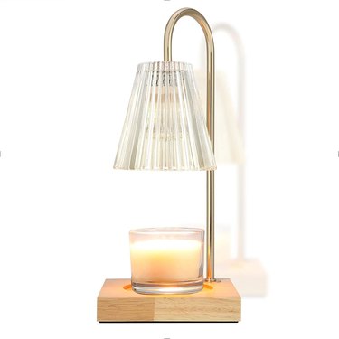 Candle warmer lamp with a gold arm, wood base, and clear fluted glass shade.