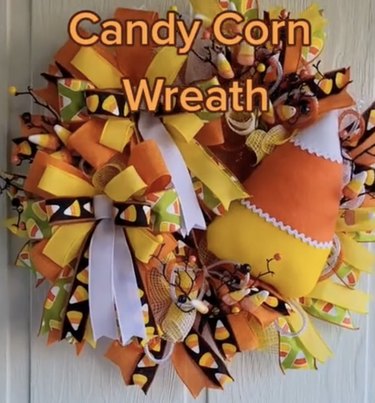 Wreath made with yellow, orange and white ribbons and a plush candy corn decoration