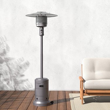 Amazon Basics patio heater, pictured on a wooden floor next to a couch or love seat