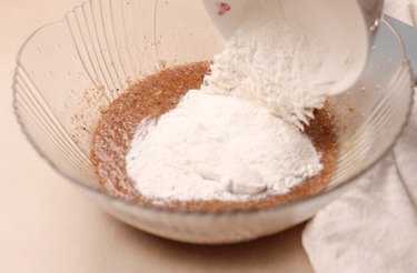 Pouring dry ingredients into mixing bowl.
