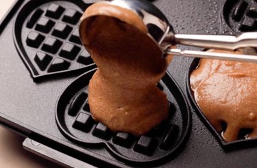 Scooping mochi waffle batter into waffle iron.