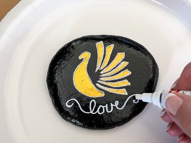 Write a word of gratitude on the rock using a paint pen