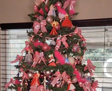 Green Christmas tree with pink decorations and real Barbie dolls