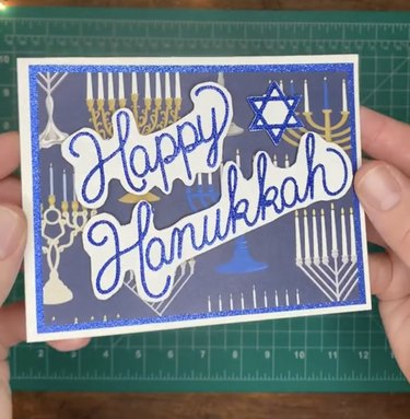 Blue, white and gold card reading "Happy Hanukkah"