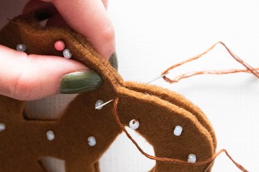 Sewing felt pretzel pieces with a blanket stitch to make an ornament