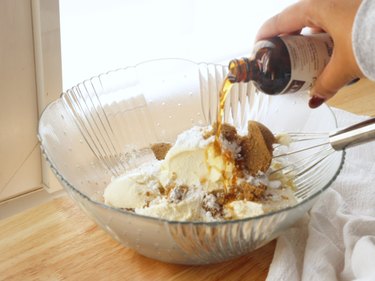 Pouring vanilla extract into bowl.