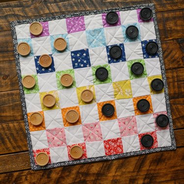 Checkerboard made from colorful fabric with wood checker pieces