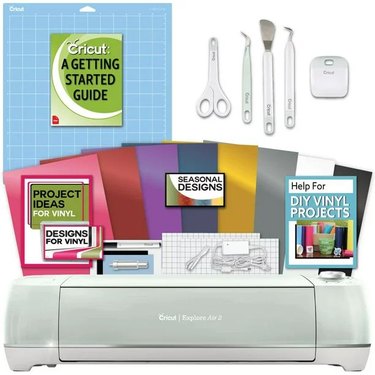 Cricut Explore Air 2 bundle in mint with vinyl, tools, and a getting started guide.