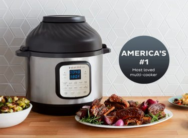 Instant Pot Duo Crisp 11-in-1 Pressure Cooker With Air Fryer Lid next to plate of meat and vegetables on kitchen counter.