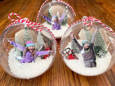 three finished photo snow globe ornaments