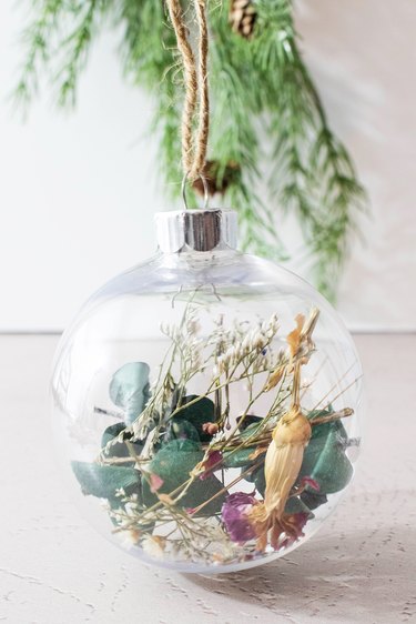 Clear ball ornament with dried flowers and stems