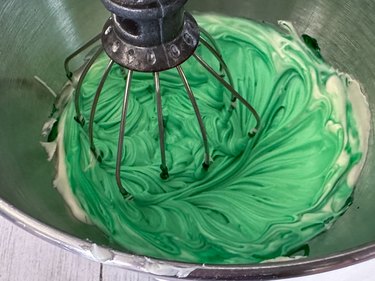 mix green food coloring into white frosting
