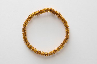 Gold pipe cleaners twisted into a circle