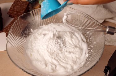 Adding powdered sugar to bowl of meringue