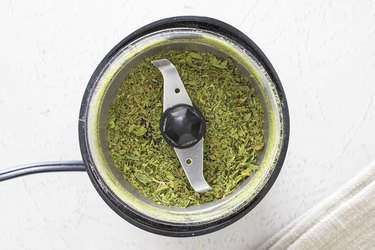 Dried celery leaves in a coffee grinder