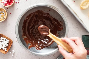 Dip cookie spoons into melted chocolate