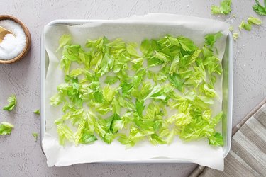 Drying fresh celery leaves on a baking sheet