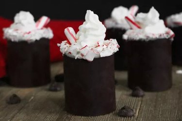 Shot glasses made of chocolate and topped with whipped cream and peppermint