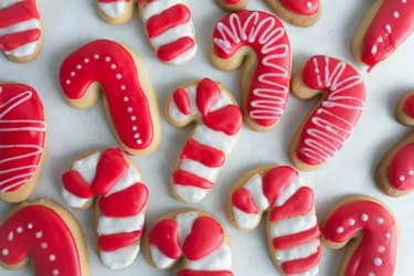 Sugar cookies shaped like candy canes with red and white frosting