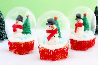 Cupcakes topped with snowmen in clear snow globes
