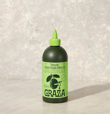 Graza "Drizzle" finishing olive oil in a two-tone squeeze bottle.
