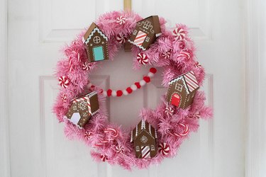 Pastel pink wreath with paper gingerbread houses and candy details