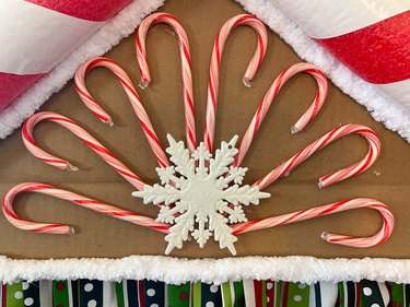 Candy canes and snowflake adhered above puppet theater window