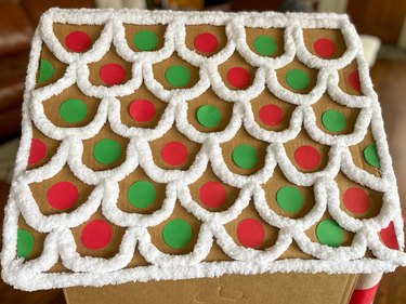 Use hot glue, thick white yarn and felt circles to decorate roof