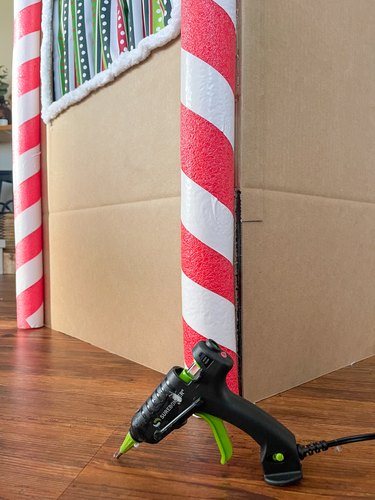 Adhere pool noodles onto front of gingerbread house puppet theater