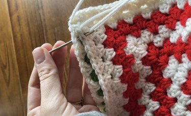 Stitching up the sides of two crochet pillow panels