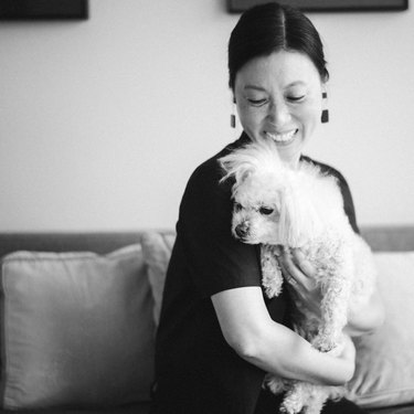 Hyun Yu, holding a dog, smiling