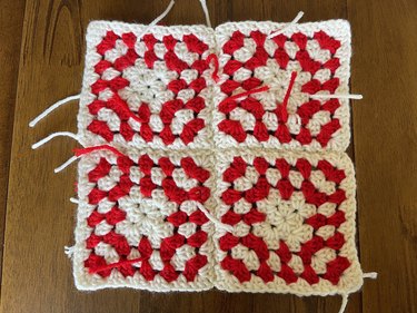 Four red and white crochet granny squares