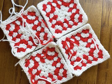 Four red and white crochet granny squares