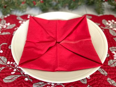 Fold newly formed corners into the center of the napkin
