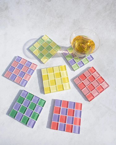 Seven checkerboard coasters in different bright color schemes
