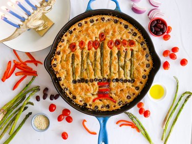 A loaf of focaccia bread topped with veggies in the shape of a menorah