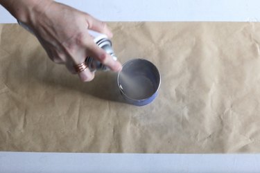 spraying gold paint inside jar