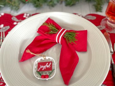 finished red Christmas bow napkin on a white plate