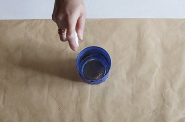 spraying vinegar inside glass jar