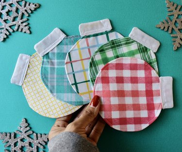 A hand holding fabric coasters
