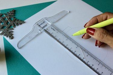 Ruler being traced on white card stock
