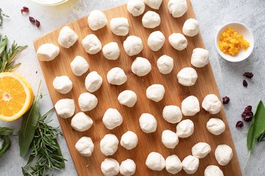 Balls of biscuit dough on a wooden cutting board