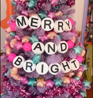 Colorful tree decorated with garland spelling out "Merry and Bright"