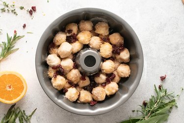 Biscuit dough and dried cranberries in a Bundt pan