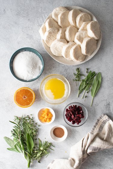 Ingredients for cranberry-orange monkey bread wreath on a gray table